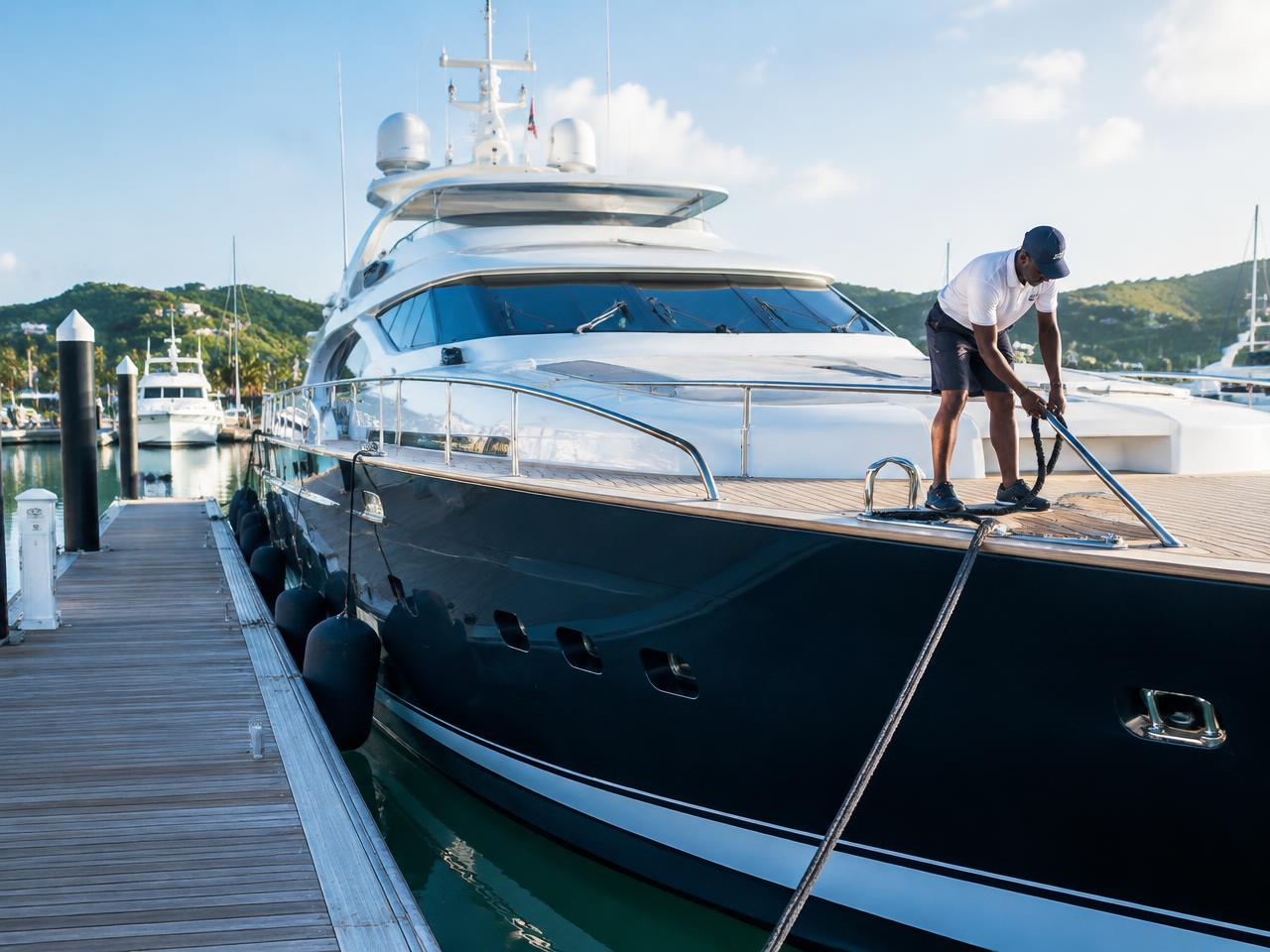 Crew member handling dock lines on a moored luxury yacht